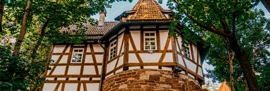 Fachwerkhaus mit rundem Turm, umgeben von B&auml;umen. Der Turm hat ein spitzes Dach, das Geb&auml;ude ist aus Holz und Stein gebaut., &copy; Stuttgart-Marketing GmbH, Thomas Niederm&uuml;ller