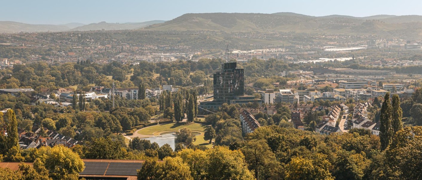 Panoramablick vom Killesbergturm auf Stuttgart. Im Vordergrund grüne Bäume, im Hintergrund Gebäude und Hügel., © Stuttgart-Marketing GmbH, Sarah Schmid