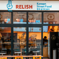 Das Bild zeigt die Fassade des Restaurants 'Relish', das koreanisches Street Food anbietet. Die Glasfront ist mit Neonlichtern dekoriert., © Stuttgart-Marketing GmbH, Sarah Schmid Das Bild zeigt die Fassade des Restaurants 'Relish', das koreanisches Street Food anbietet. Die Glasfront ist mit Neonlichtern dekoriert., © Stuttgart-Marketing GmbH, Sarah Schmid