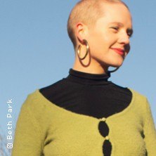Person mit kurzem Haar, großen Ohrringen und grünem Oberteil vor blauem Himmel., © links im Bild Person mit kurzem Haar, großen Ohrringen und grünem Oberteil vor blauem Himmel., © links im Bild
