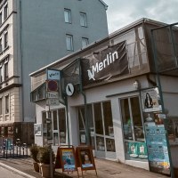 Straßenszene in Stuttgart mit dem Kulturzentrum Merlin e.V. rechts im Bild. Die Sonne scheint, Autos parken entlang der Straße., © Merlin, Stuttgart Straßenszene in Stuttgart mit dem Kulturzentrum Merlin e.V. rechts im Bild. Die Sonne scheint, Autos parken entlang der Straße., © Merlin, Stuttgart