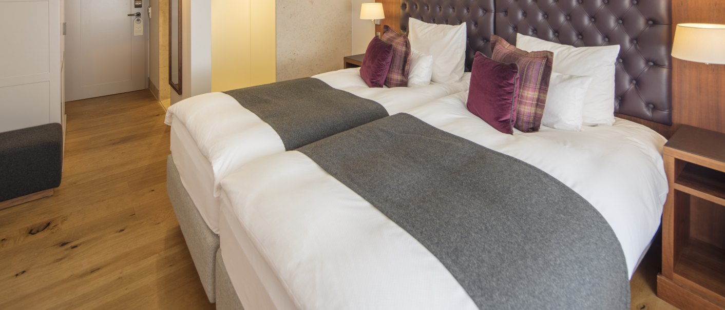 A stylishly furnished double room with a large bed, wooden floor and elegant lighting., &copy; Waldhotel Stuttgart GmbH