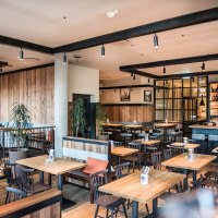 Modern brewery with wooden furniture, bar and plants. Cozy atmosphere with wooden walls and stylish lighting., &copy; Andreas Engelhard - Engelhard Photography