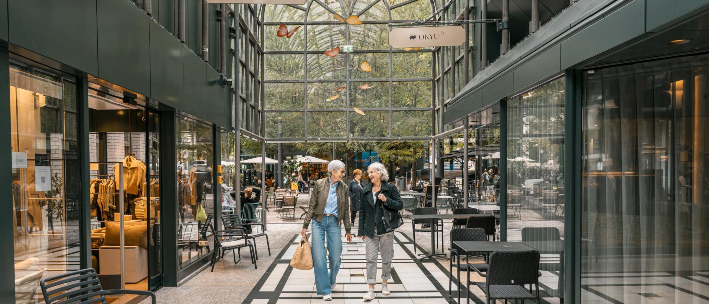 Two people stroll through the Calwer Passage with its stores and caf&eacute;s. The arcade has a glass roof and a modern design., &copy; Stuttgart-Marketing GmbH, Sarah Schmid