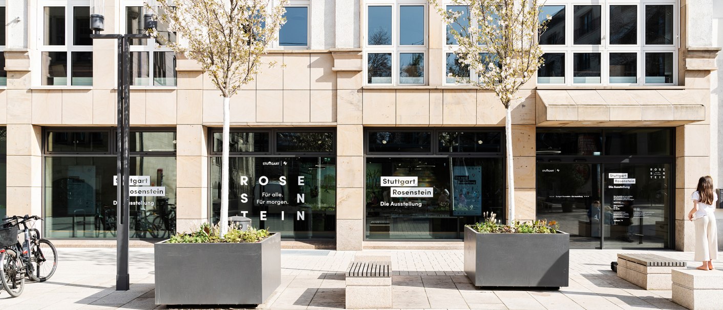 Entrance to the Stuttgart Rosenstein exhibition with glass front, lettering and trees. A person stands on the right, bicycles on the left., © Dominique Brewing Entrance to the Stuttgart Rosenstein exhibition with glass front, lettering and trees. A person stands on the right, bicycles on the left., © Dominique Brewing