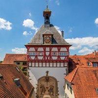 A half-timbered building with a clock tower in Bietigheim-Bissingen, surrounded by red-tiled roofs and a blue sky., &copy; &copy; Stuttgart-Marketing GmbH