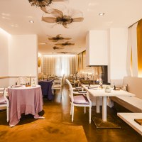 Elegantes Restaurant mit stilvoller Dekoration, gedeckten Tischen und warmem Licht. Blumenmuster an der Decke und moderne Einrichtung schaffen eine einladende Atmosphäre., © Zauberlehrling Elegantes Restaurant mit stilvoller Dekoration, gedeckten Tischen und warmem Licht. Blumenmuster an der Decke und moderne Einrichtung schaffen eine einladende Atmosphäre., © Zauberlehrling