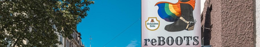 A sign with a boot and a rainbow flag, next to it the inscription 'reBOOTS'. Buildings and a tree can be seen in the background., © SMG Stuttgart Marketing GmbH - Sarah Schmid