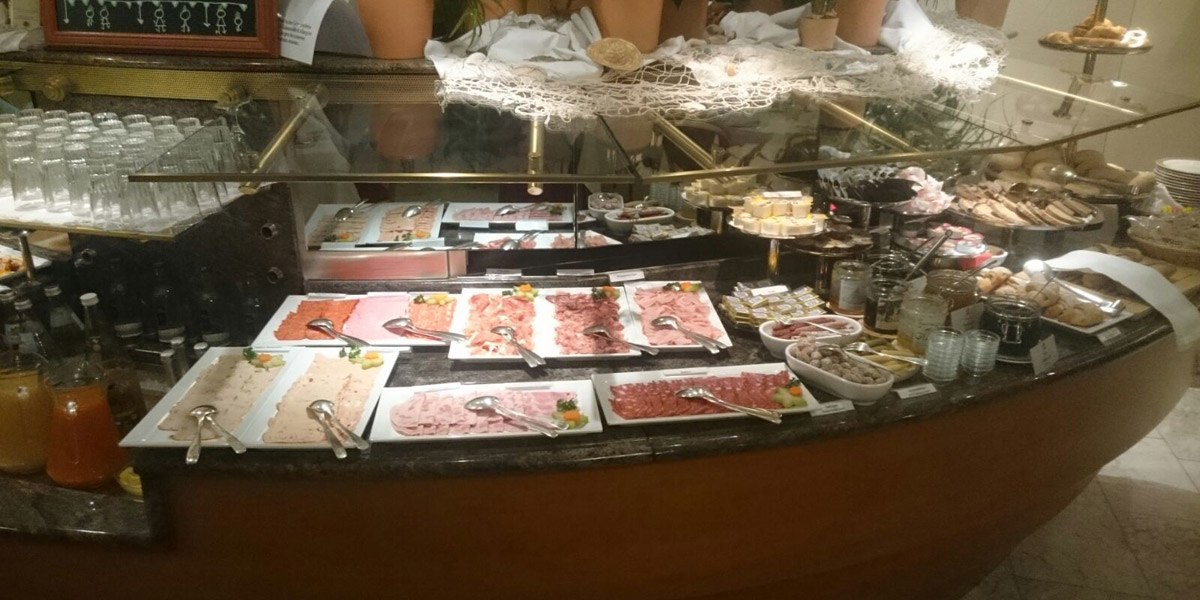 Ein Frühstücksbuffet mit verschiedenen Wurstsorten, Aufstrichen, Gläsern und Getränken. Im Hintergrund sind Brot und Gebäck zu sehen., © Hotel Unger Ein Frühstücksbuffet mit verschiedenen Wurstsorten, Aufstrichen, Gläsern und Getränken. Im Hintergrund sind Brot und Gebäck zu sehen., © Hotel Unger