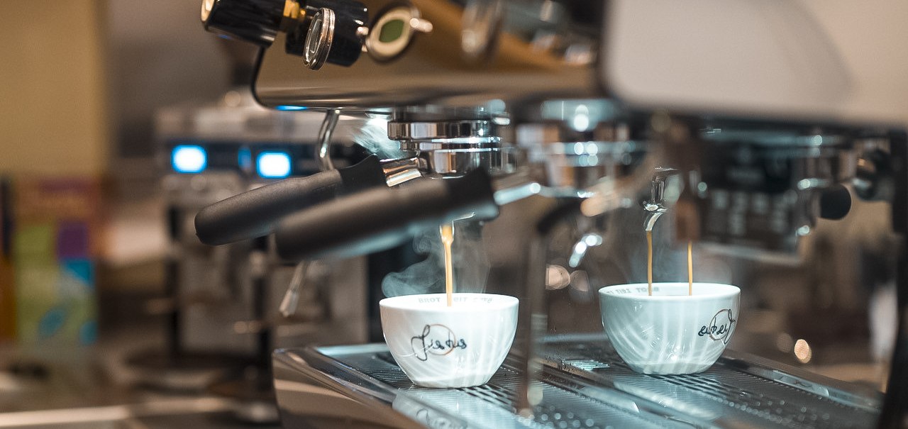 Eine Espressomaschine brüht frischen Kaffee in zwei weiße Tassen. Der Kaffee fließt in einem dünnen Strahl in die Tassen., © Café Justus, Stuttgart Eine Espressomaschine brüht frischen Kaffee in zwei weiße Tassen. Der Kaffee fließt in einem dünnen Strahl in die Tassen., © Café Justus, Stuttgart