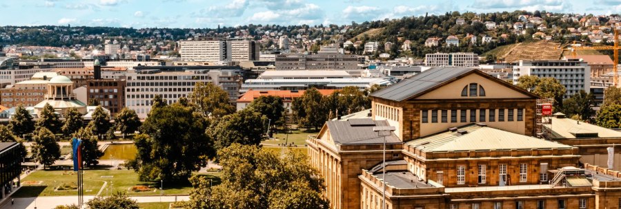 Panoramablick auf eine Stadt mit historischen Gebäuden, grünen Parks und Hügeln im Hintergrund unter einem blauen Himmel mit Wolken., © Stuttgart-Marketing GmbH, Sarah Schmid Panoramablick auf eine Stadt mit historischen Gebäuden, grünen Parks und Hügeln im Hintergrund unter einem blauen Himmel mit Wolken., © Stuttgart-Marketing GmbH, Sarah Schmid