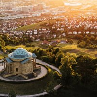 Luftaufnahme der Grabkapelle auf dem Württemberg in Stuttgart, umgeben von Weinbergen und Stadtlandschaft im Sonnenuntergang., © SMG, Cornelius Bierer