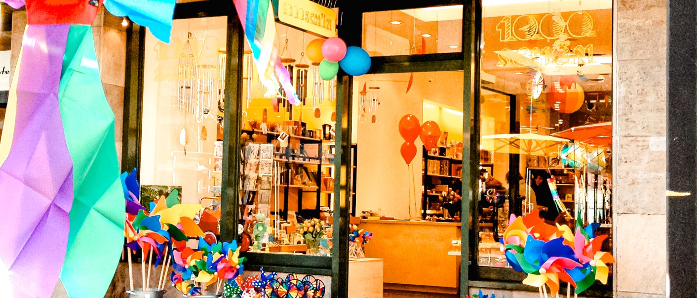 A store with colorful decorations, including pinwheels and balloons, attracts attention. The entrance is invitingly designed., &copy; 1000sch&ouml;n