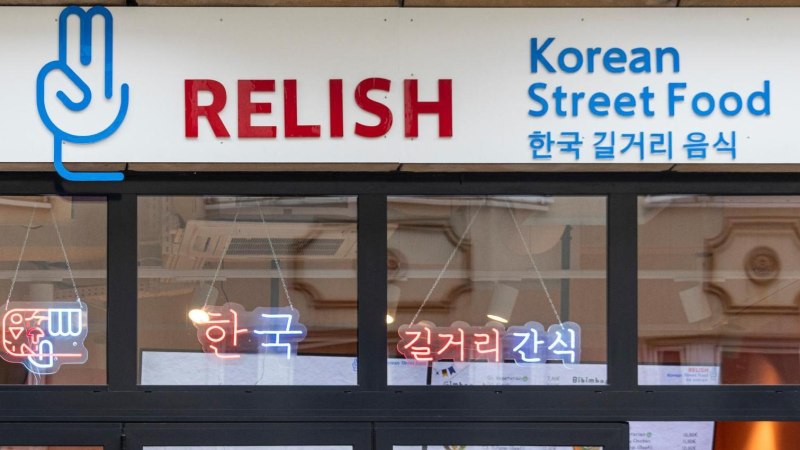 Eingang eines Restaurants mit dem Schild 'Relish Korean Street Food' und koreanischen Schriftzeichen. Neonlichter im Fenster., &copy; Stuttgart-Marketing GmbH, Sarah Schmid