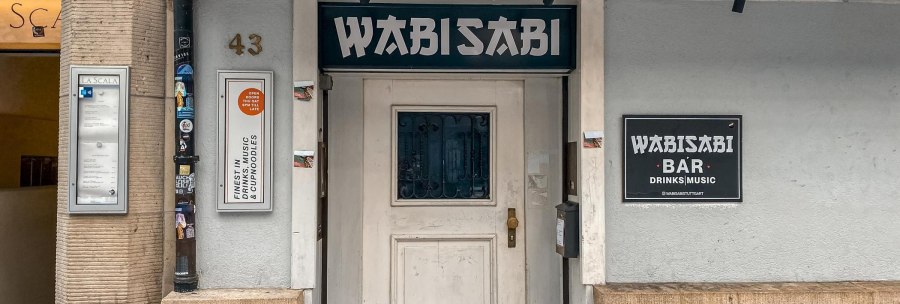 Außenansicht der Wabisabi Bar mit Eingangstür, Schildern und der Hausnummer 43. Die Bar bietet Drinks, Musik und Cup Noodles an., © SMG Außenansicht der Wabisabi Bar mit Eingangstür, Schildern und der Hausnummer 43. Die Bar bietet Drinks, Musik und Cup Noodles an., © SMG