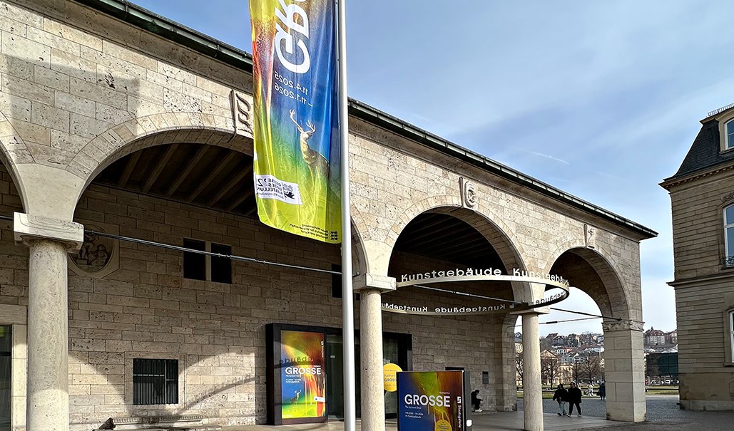 Entrance to the Staatsgalerie with colorful posters for Katharina Grosse's exhibition. A large banner hangs on a pole., © Staatsgalerie