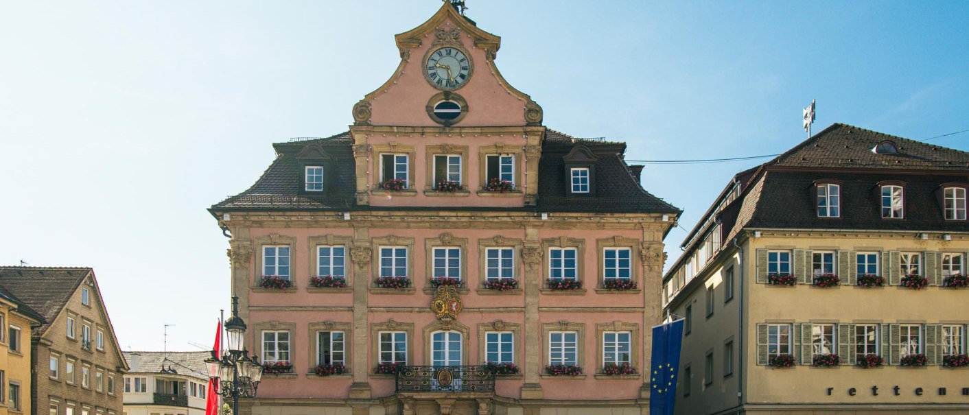 The historic town hall of Schwäbisch Gmünd on the market square, with a clock in the gable and windows decorated with flowers, in sunny weather., © Stuttgart-Marketing GmbH, Sarah Schmid