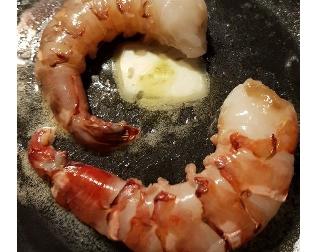 Two raw prawns in a pan with melting butter, ready to cook., &copy; Kultweine-Kochwelten-Kunst&uuml;cke - Kochschule Sonja Lenz