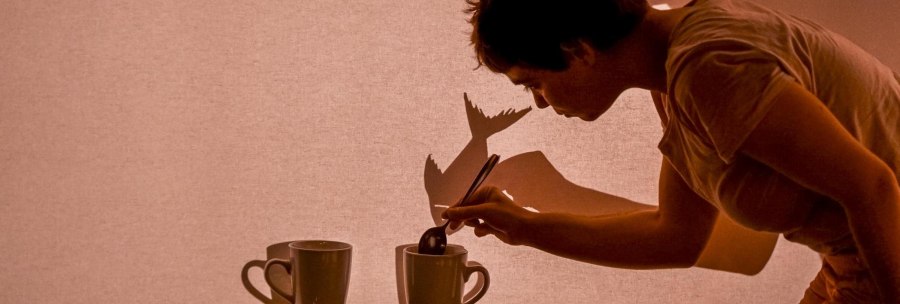 Person stirs in a cup, projects shadows onto a screen. Creative play with light and shadow., &copy; FITZ! Stuttgart