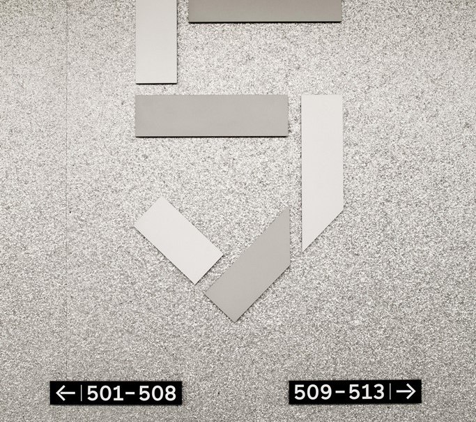 Grey wall with stylized number 5 and signs showing room numbers: 501-508 left, 509-513 right, 514-518 left., &copy; Hotel am Remspark