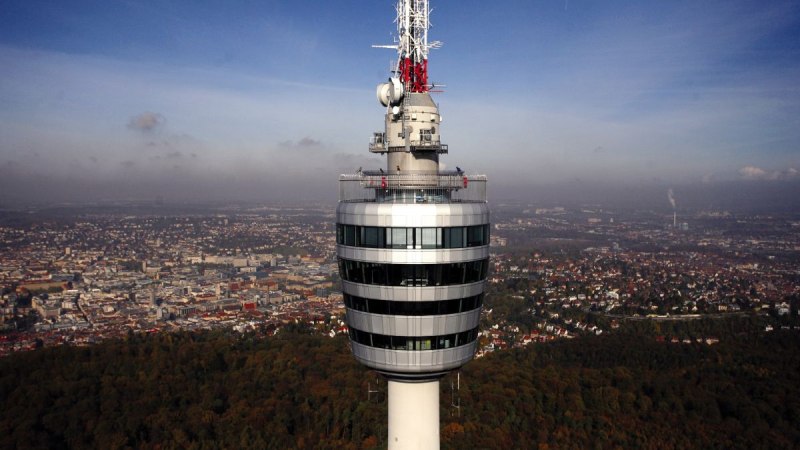 Der Fernsehturm Stuttgart ragt über die Stadtlandschaft, umgeben von bewaldeten Gebieten und urbanen Strukturen unter einem klaren blauen Himmel., © Stuttgart-Marketing GmbH, Achim Mende Der Fernsehturm Stuttgart ragt über die Stadtlandschaft, umgeben von bewaldeten Gebieten und urbanen Strukturen unter einem klaren blauen Himmel., © Stuttgart-Marketing GmbH, Achim Mende
