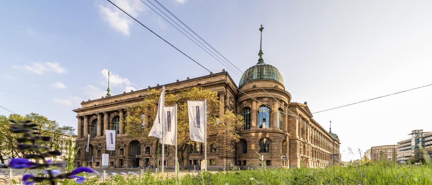 The Haus der Wirtschaft in Stuttgart with its magnificent fa&ccedil;ade and dome, surrounded by flags and green vegetation., &copy; &copy; Stuttgart-Marketing GmbH, Werner Dieterich