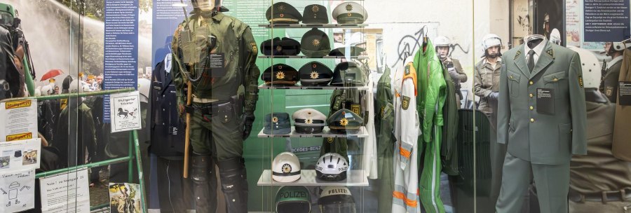 Ausstellung im Polizeimuseum Stuttgart mit verschiedenen Polizeiuniformen, Helmen und Ausrüstungsgegenständen in einer Vitrine., © Stuttgart-Marketing GmbH, Sarah Schmid