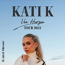 Frau mit blondem Haar vor blauem Himmel. Schriftzug: 'KATI K - Von Herzen Tour 2025'. Fotograf: Jakob Marwein., © links im Bild