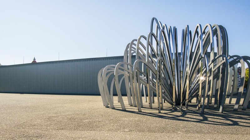 Modern sculpture made of bent metal struts in front of the Stihl Gallery in Waiblingen, under a clear sky and sunshine., © SMG Stuttgart Marketing GmbH - Sarah Schmid