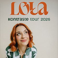 Frau mit roten Haaren und gestreiftem Hemd blickt nach oben. Text: 'Loua Kontraste Tour 2026' in orange und grün., © links im Bild
