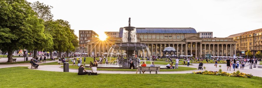 Schlossplatz in Stuttgart bei Sonnenuntergang, Menschen entspannen sich auf der Wiese, im Hintergrund der Königsbau und ein Brunnen., © Stuttgart-Marketing GmbH, Werner Dieterich