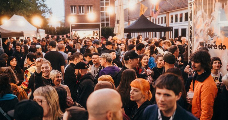 Gro&szlig;e Menschenmenge bei einem Outdoor-Event mit festlicher Beleuchtung und verschiedenen St&auml;nden im Hintergrund., &copy; Ilkay Karakurt