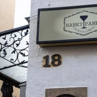 Ein Schild mit der Aufschrift 'Hanky Panky Cocktail & co' hängt an einer Hauswand neben der Hausnummer 18. Eine Laterne und ein dekoratives Vordach sind sichtbar., © Stuttgart-Marketing GmbH, Sarah Schmid Ein Schild mit der Aufschrift 'Hanky Panky Cocktail & co' hängt an einer Hauswand neben der Hausnummer 18. Eine Laterne und ein dekoratives Vordach sind sichtbar., © Stuttgart-Marketing GmbH, Sarah Schmid
