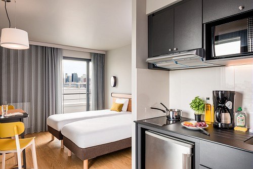Modern hotel room with two single beds, kitchenette, dining table and city view through the window., &copy; adagio access Stuttgart Airport Messe