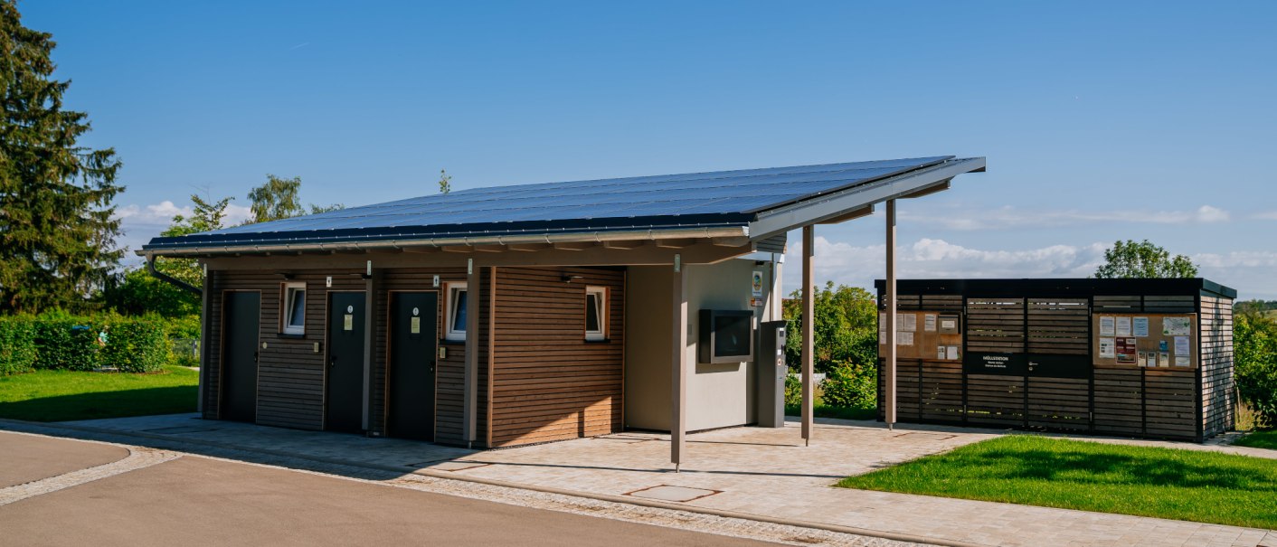 A modern building with a solar roof and wooden walls, with an information sign next to it. The surroundings are green and well-maintained, with a clear sky in the background., © Thomas Niedermüller A modern building with a solar roof and wooden walls, with an information sign next to it. The surroundings are green and well-maintained, with a clear sky in the background., © Thomas Niedermüller