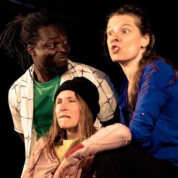 Drei Personen auf einer Bühne. Eine Frau in Blau spricht leidenschaftlich, während ein Mann und eine Frau mit Mütze aufmerksam zuhören., © Wilhelma Theater