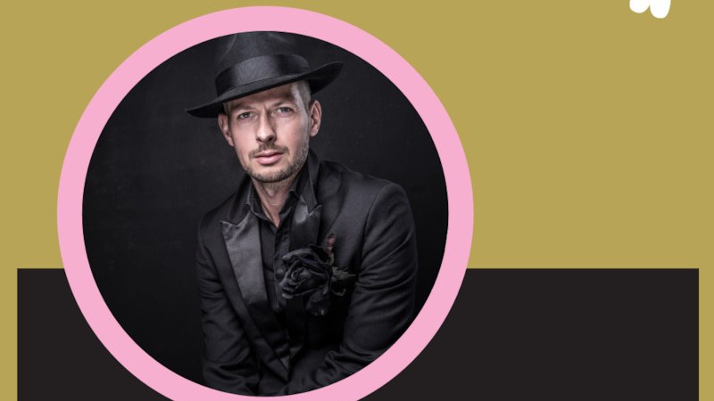 Ein Mann in elegantem schwarzen Anzug und Hut, mit einer schwarzen Rose am Revers, posiert vor einem dunklen Hintergrund., &copy; Renitenztheater Stuttgart e.V.