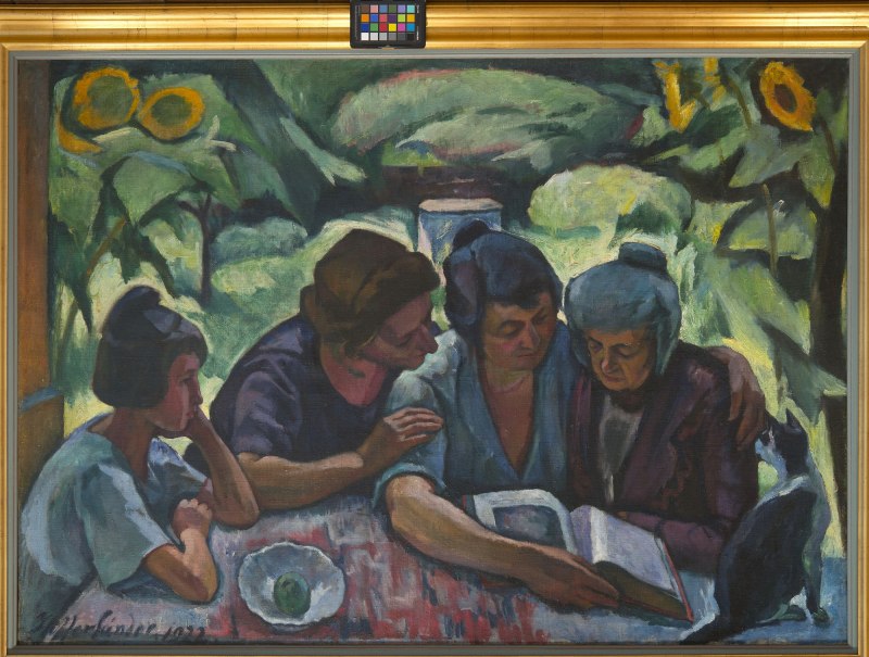 Vier Frauen sitzen an einem Tisch und lesen gemeinsam ein Buch. Im Hintergrund sind grüne Pflanzen und Sonnenblumen zu sehen. Ein schwarzer Hund sitzt daneben., © Jozsef Böhm