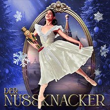 Eine Ballerina in einem weißen Kleid hält einen Nussknacker vor einer winterlichen Kulisse mit Schneeflocken und einem Schloss., © links im Bild