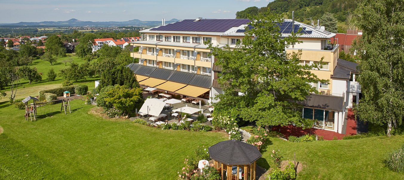 Das Badhotel Restaurant Stauferland mit Terrasse, Garten und Spielplatz, umgeben von grüner Landschaft und Hügeln im Hintergrund., © Badhotel Restaurant Stauferland