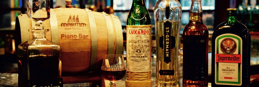Eine Bar mit Spirituosenflaschen wie Luxardo, St-Germain und J&auml;germeister neben einem Holzfass der Maritim Hotel Stuttgart Piano Bar., &copy; Maritim Hotels