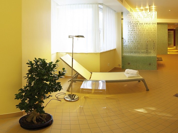 Bright wellness area with lounger, plant and decorative glass wall. Relaxing atmosphere with warm yellow tones and modern furnishings., &copy; relexa Waldhotel Schatten