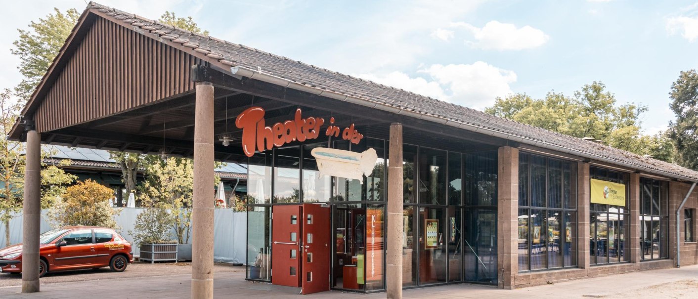 Eingang des Theaters in der Badewanne mit Glasfront und rotem Auto davor. Ein Schild mit dem Theaternamen und einer Badewanne ist sichtbar., &copy; Stuttgart Marketing GmbH, Sarah Schmid