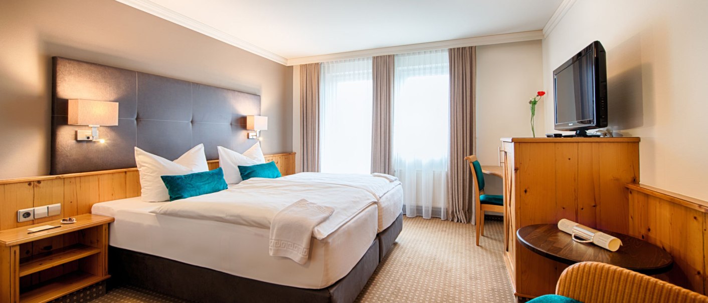 Gemütliches Hotelzimmer mit Doppelbett, Holzmöbeln, Fernseher und Fenster mit Vorhängen. Helle, einladende Atmosphäre., © Landhaus Franz Feckl Gemütliches Hotelzimmer mit Doppelbett, Holzmöbeln, Fernseher und Fenster mit Vorhängen. Helle, einladende Atmosphäre., © Landhaus Franz Feckl