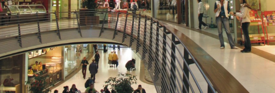 Innenansicht der Königsbau Passagen mit Geschäften und Menschen auf zwei Etagen. Eine geschwungene Brücke verbindet die Bereiche., © Stuttgart-Marketing GmbH