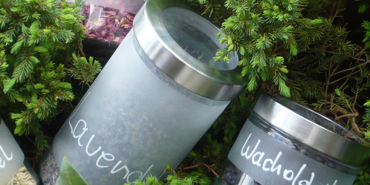 Two glass containers with lavender and juniper, surrounded by green branches, convey a feeling of nature and relaxation., &copy; Hotel Hochwald
