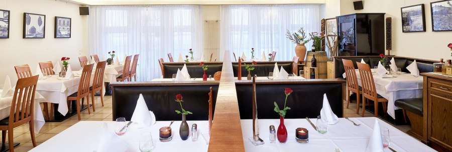 Elegant restaurant with white tablecloths, wooden chairs and decorative roses on the tables. Bright, inviting atmosphere., &copy; Frank Pham
