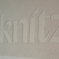 Das Logo des knitz Restaurants ist in großen, weißen Buchstaben auf einer strukturierten Wand zu sehen., © Stuttgart-Marketing GmbH