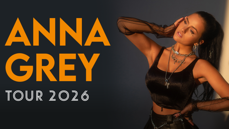 Eine Frau in einem schwarzen Outfit posiert neben dem Schriftzug 'Anna Grey Tour 2026'. Sie tr&auml;gt Schmuck und hat eine selbstbewusste Haltung., &copy; links im Bild