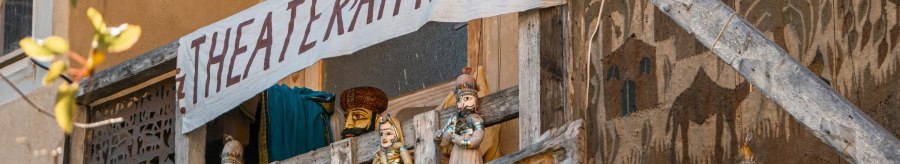 A wooden balcony with puppets and a hand-painted banner 'Theater am Faden'. The puppets are traditionally dressed., © SMG Stuttgart Marketing GmbH - Sarah Schmid